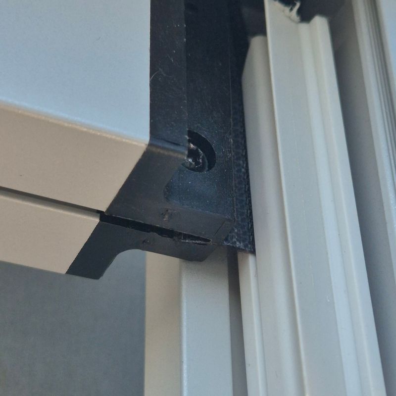 Nærbilde av hjørnet på en ZIP Screen der duken med glidelås går ned i PVC-skinnen under kassetten