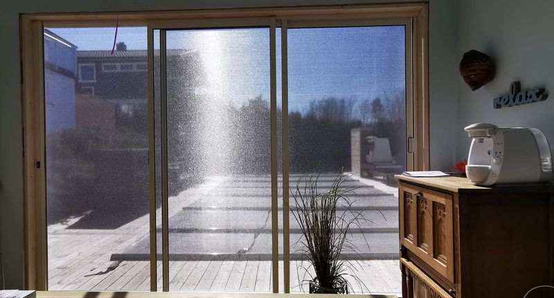 Utsyn gjennom mørk screenduk med 1 % åpning mot en terrasse